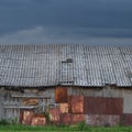 Old aged weathered wooden shack, grey plated wood boarding hut wall, patched planks, rusted metal plates, rusty paint texture Royalty Free Stock Photo