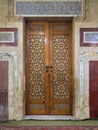 Old aged wooden closed door decorated with arabesque ornaments Royalty Free Stock Photo