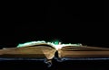 Old , aged, yellow opened book, glowing optical fibres