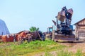 An old agricultural tractor stands in a collective farm yard waiting for work