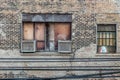 Old air conditioner boxes attached to boarded up windows on side of vintage brick building in Chicago Royalty Free Stock Photo