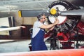 Aircraft mechanic repairs an aircraft engine in an airport hangar Royalty Free Stock Photo