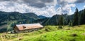 Old alpine hut with meadow in the Alps. Bavaria, Allgau, Germany. Traditional agriculture in the mountains. Royalty Free Stock Photo