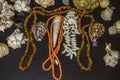 Old amber and coral beads with shells and stones lying on black plywood