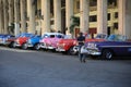 Old american cars are parked in the shadow of a building on Calle Animas