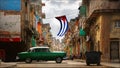 Old American green red car in the old city of Havana against the backdrop of Spanish colonial architecture.