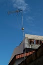 Old analog antenna for television stand tall between houses and buildings