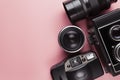 Old analog cameras and lenses on a pink table