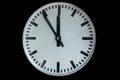 Old analog clock showing five to twelve isolated on black Royalty Free Stock Photo