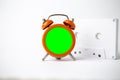Old analog orange clock on a white background. The central part of the sart is green blank, left for inserting some content, and