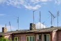 Old analog television antennas of meter and decimeter ranges on the roof with two chimneys Royalty Free Stock Photo