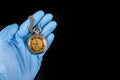 Old analog watch on a latex glove. Hand of a medical worker in a glove with a watch on his hand