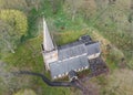 Old ancient aerial view of village historic catholic christian church. Tall spire with weather vane on steeple and winding pathway Royalty Free Stock Photo