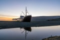 Old ancient, destroyed and abandoned norwegian whaling ship laying ashore in the westfjords of Iceland during sunset.
