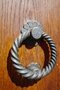 Old ancient door knocker on wooden door Royalty Free Stock Photo