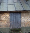 Old building with tin roof brick wall and wood door Royalty Free Stock Photo
