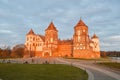 Old, ancient medieval castle with spiers and towers, walls of stone and brick surrounded by a protective moat with water Royalty Free Stock Photo