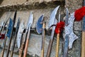 The old ancient medieval cold weapons, axes, olibards, knives, swords with wooden handles lick on the stone steps of the castle