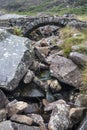 Old ancient packhorse bridge over mountain stream in Autumn Royalty Free Stock Photo
