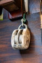 old ancient sailing pulley made from timber hanging from a hook at the wall Royalty Free Stock Photo