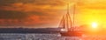 Old ancient ship on peaceful ocean at sunset. Calm waves reflection, sun setting. Copy space Royalty Free Stock Photo