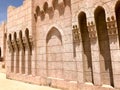 An old ancient yellow stone strong wall with arches in patterns and columns in an Arab Muslim Islamic warm tropical country in the