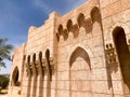 An old ancient yellow stone strong wall with arches in patterns and columns in an Arab Muslim Islamic warm tropical country in the