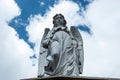 An old angel sculpture looking down in low angle shooting in mysterious form