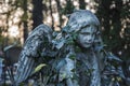 Old angel statue which has become overgrown with ivy religion, death concept Royalty Free Stock Photo