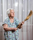 Old angry woman threatening with a broom Royalty Free Stock Photo