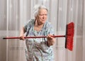 Old angry woman threatening with a broom