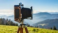 old antique bellows film camera on wooden tripod taking picture of landscape, outdoors photography, close up side rear view of Royalty Free Stock Photo