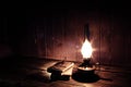 Old antique books with burning paraffin lamp near on the wooden table. Royalty Free Stock Photo