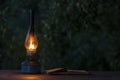 Old antique burning kerosene lamp with open book on the wooden table, copy space Royalty Free Stock Photo