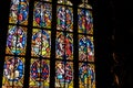 Old antique colorful stained glass windows in a darkened church, saints, bible scenes religious art decoration detail, closeup