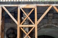 Old antique Corinthian Greek column capital top part and a wooden scaffolding closeup, nobody, no people. Old architecture Royalty Free Stock Photo