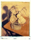 Old antique fan with metal blades sitting on table