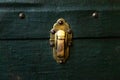 Old antique golden metal lock on green textile suitcase, close-up. Vintage retro styled textured toned Royalty Free Stock Photo