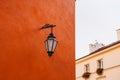 Old antique metal lamp at the beautiful red wall. Victorian vintage street lantern at the day time, turned off. The wall Royalty Free Stock Photo