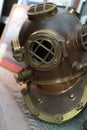 Old antique metal scuba helmet on the ground. Historic copper aqualung for diving in the ocean water