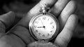 Old antique pocket watch showing time being held in hand. Close up black and white photography Royalty Free Stock Photo
