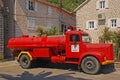 An old antique red fire fighter engine lorry truck on display in Perast, Montenegro outside of the fire department