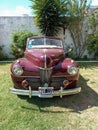 Old red 1941 Ford V8 Super Deluxe convertible club coupe in a park. CADEAA 2023 classic car show