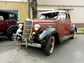 Old antique red maroon 1935 Ford V8 coupe parked in the street. Chromes. Grille. Classic car show. Royalty Free Stock Photo