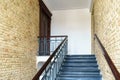 An old antique staircase in a historic building. An empty staircase and brick walls. Cast iron railings framed by wood Royalty Free Stock Photo