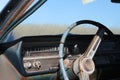 Old antique vintage retro rustic rusty dirty car steering wheel dashboard window outdoors in a field.