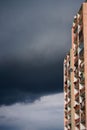 Old apartament flat building skyrise on dark stormy sky background