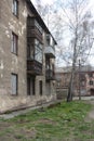 Old apartment building with destroyed facade balconies dirty passage in the yard in autumn Royalty Free Stock Photo