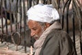 Old Arab sitting on the curb of the street near the mosque Royalty Free Stock Photo