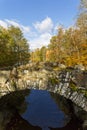 Old arch bridge over a river in a forest landscape in autumn Royalty Free Stock Photo